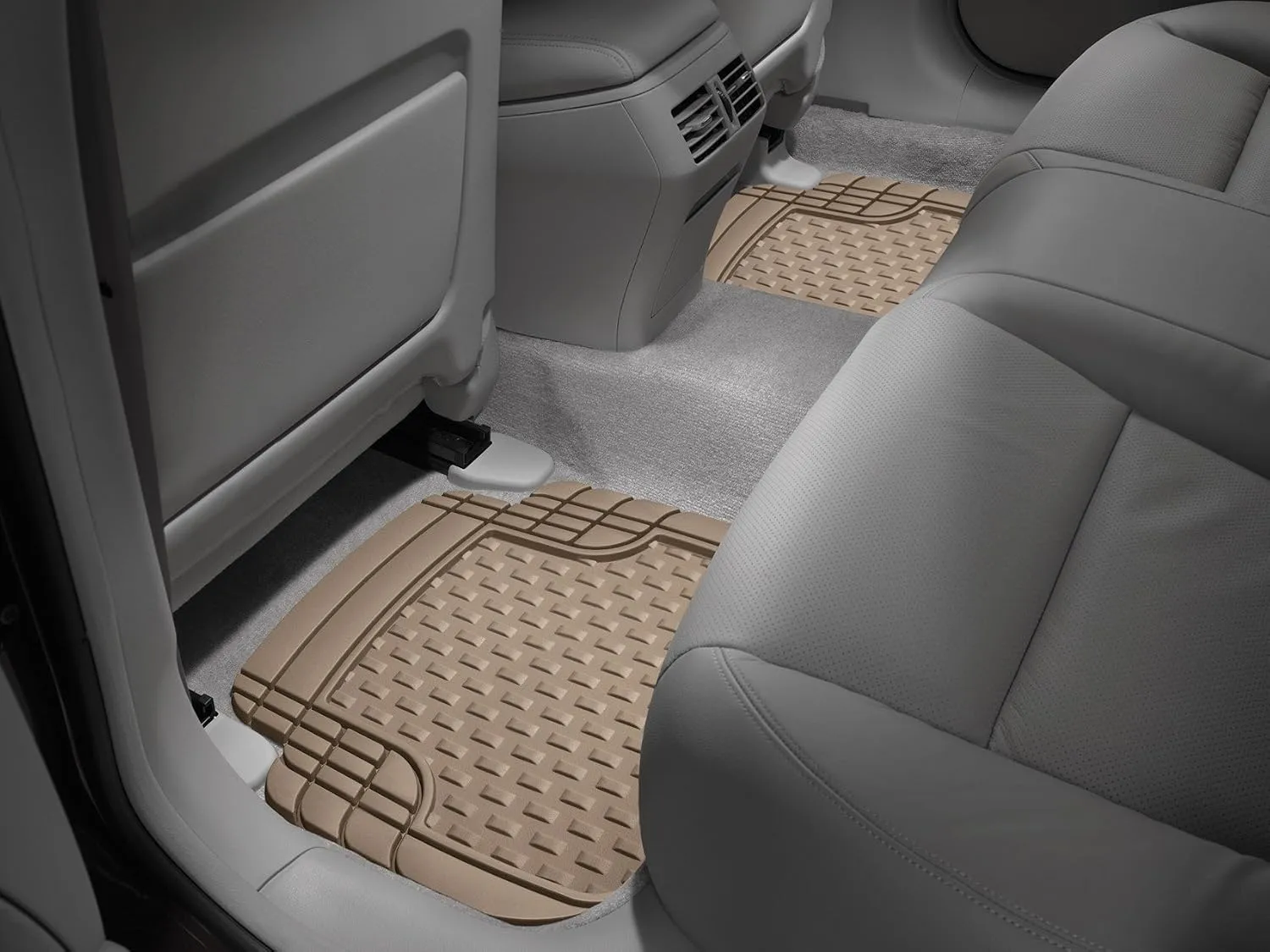 WeatherTech Trim-to-Fit rear floor mats installed in a car, tan colour with raised ridged tread pattern